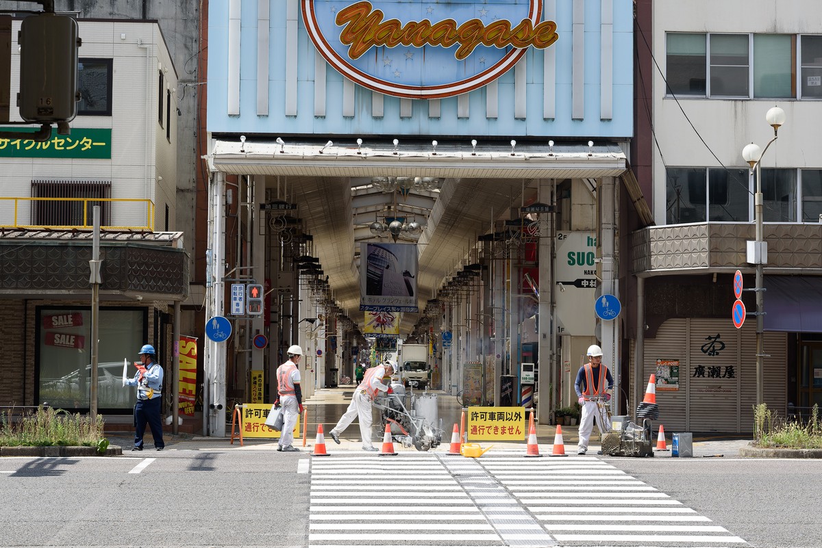 商店街の入口で道路工事をする人々
